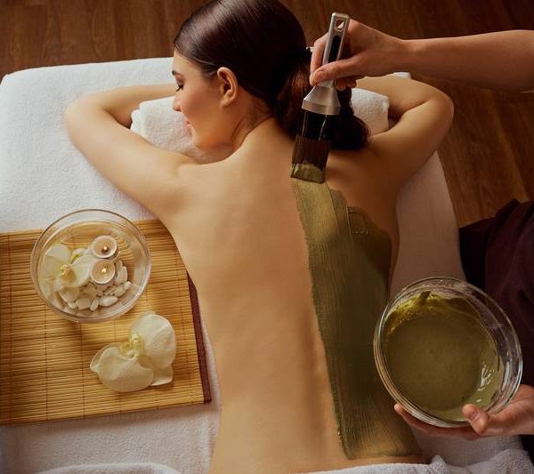 Young woman is put on a mask on her back in spa salon Young woman is put on a mask on her back in spa salon.