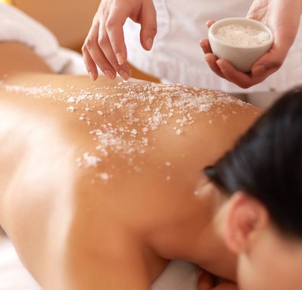 Spa Woman. Brunette Getting a Salt Scrub Beauty Treatment in the Health Spa. Body Scrub.