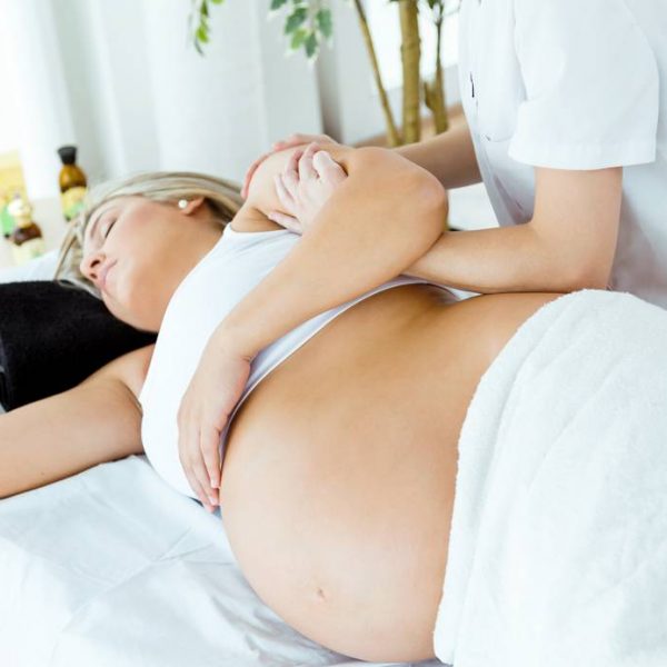 Portrait of beautiful pregnant woman having a massage in spa.