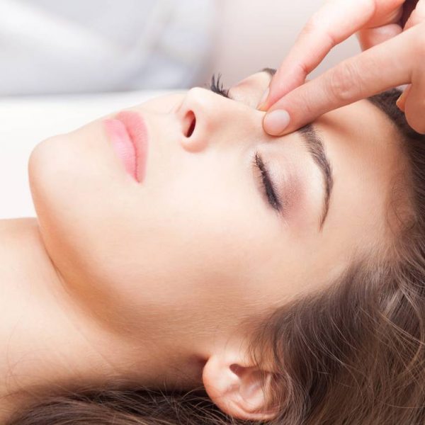 woman acupressure face massage closeup